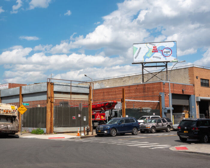 rikers island billboard on top of building at street corner