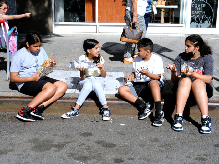 kids sit on the curb and eat at fin on 5th avenue