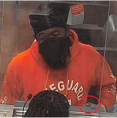 The alleged lifeguard bandit is seen in a red "Lifeguard" hoodie at the scene of the crime. Ricardo Subero, the defendant, suspectedly flashed a gun to the bank teller while demanding money.
