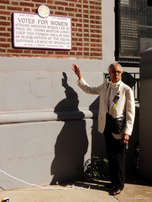 judith burgess with women's suffrage plaque