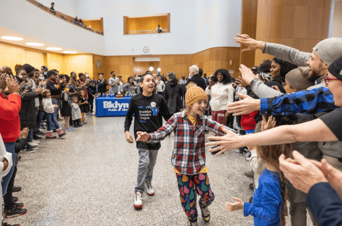 burnam and rojas high-five other kids at the championship