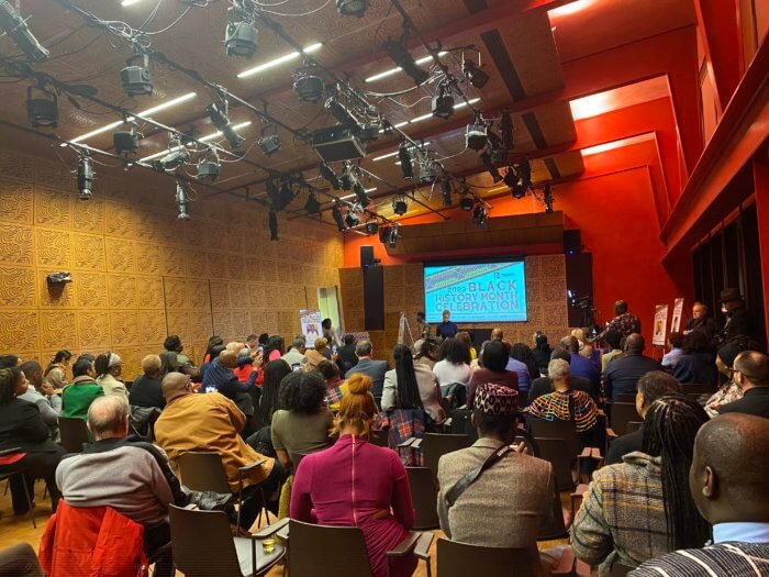 crowd watches performance at Black History Month Event.