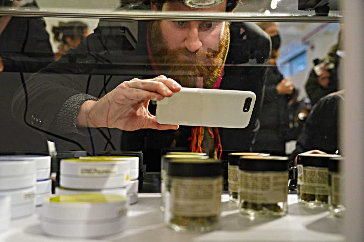 man perusing cannabis dispensary shelf