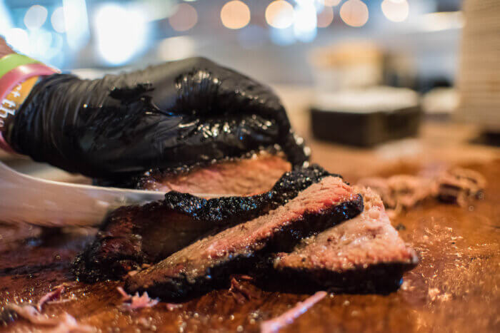 hand cutting meat mighty quinn's barbeque