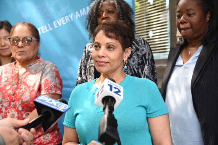 woman speaking to microphone at teal event