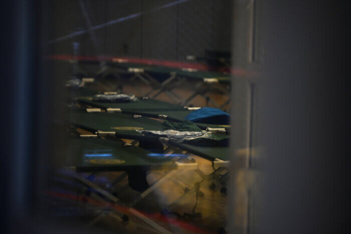 A look into the shelter shows pop up beds spread out in the public school gym.