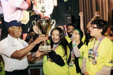 Mayor Adams hands trophy of the Minecraft Battle of the Boroughs