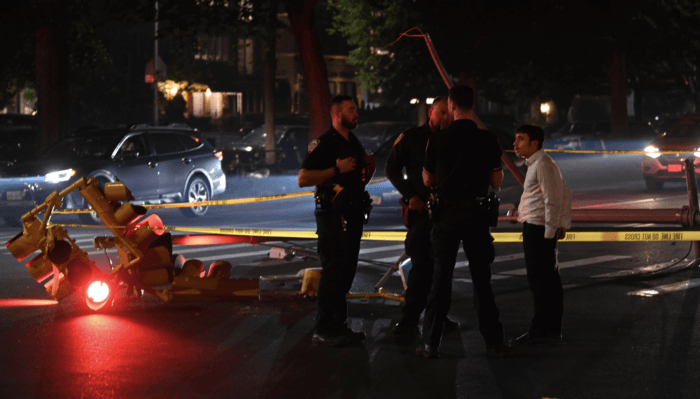 Police officers gather following a fatal hit and run.