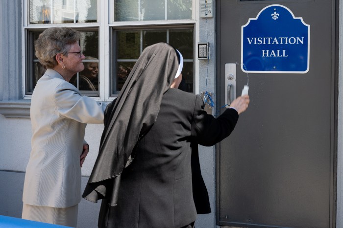 women blessing school with holy water