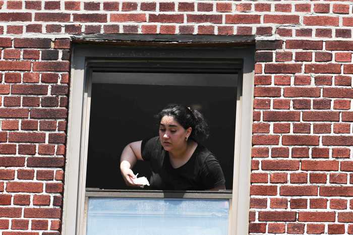 woman waving from window of burning building
