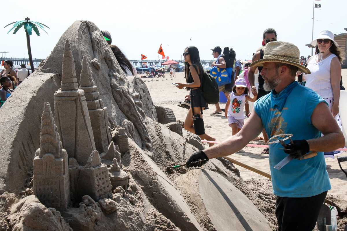 man working at sand sculpting contest