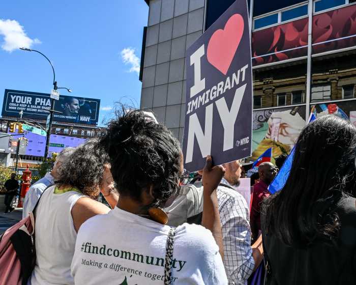 woman holding i love immigrant new york sign